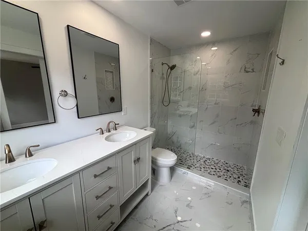 a bathroom with a sink a toilet and shower