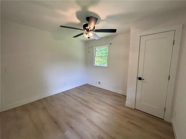an empty room with a window and a ceiling fan