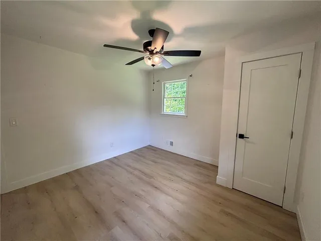an empty room with a window and a ceiling fan