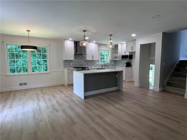 a kitchen with stainless steel appliances granite countertop a stove a refrigerator and a wooden cabinets