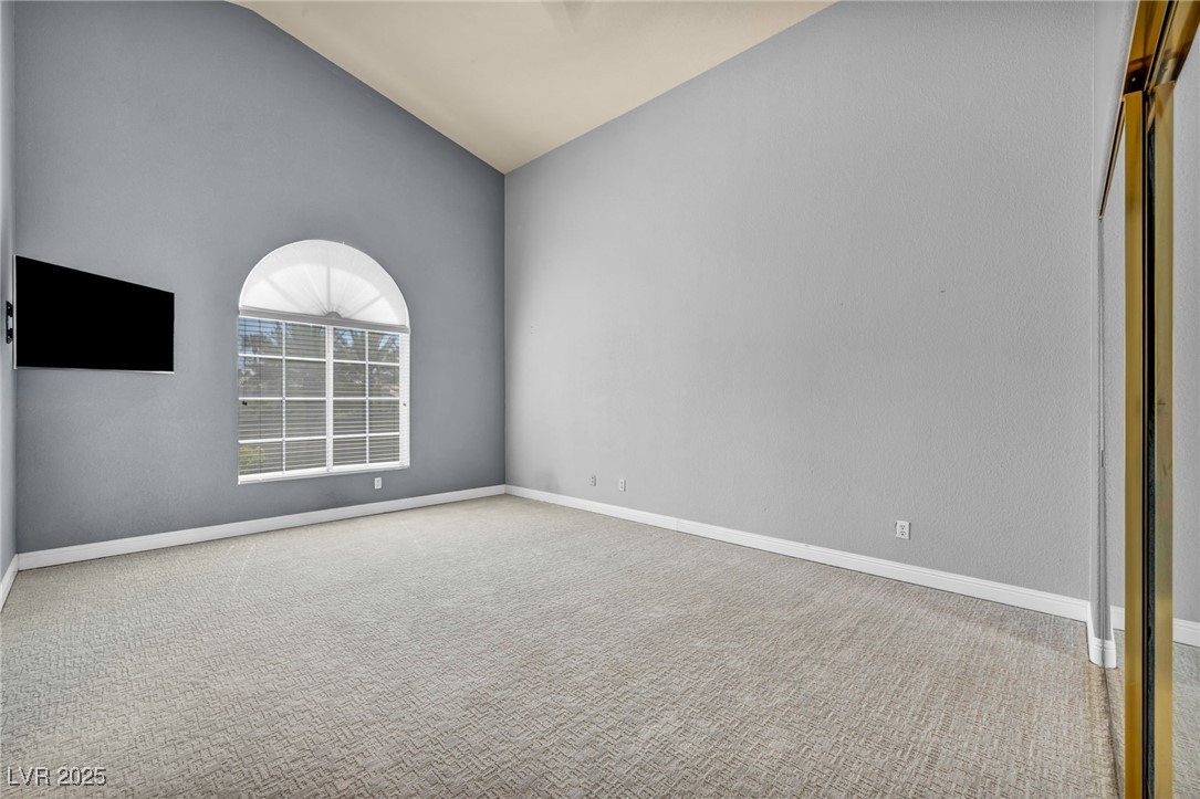 2107 Eaglepath Circle Henderson, NV 89074 - Photo 19 of 84 2nd Bedroom with light colored carpet and high vaulted ceiling