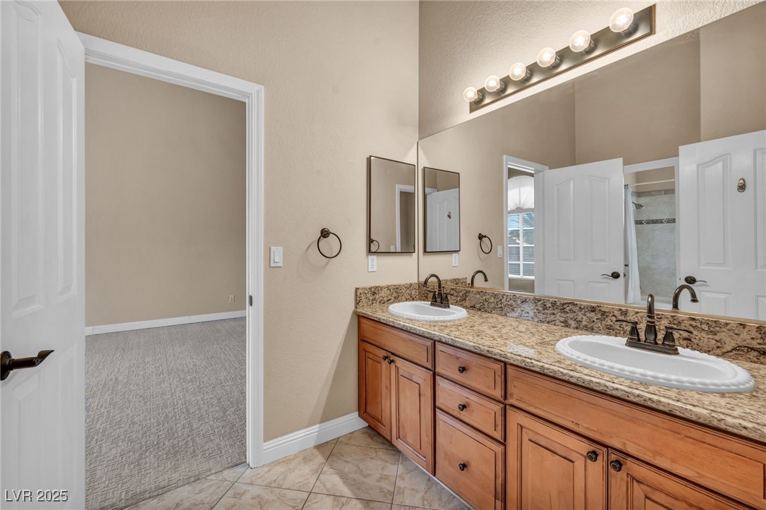 2107 Eaglepath Circle Henderson, NV 89074 - Photo 42 of 84 Full bath featuring double vanity, a shower stall, a textured wall, and light tile patterned floors