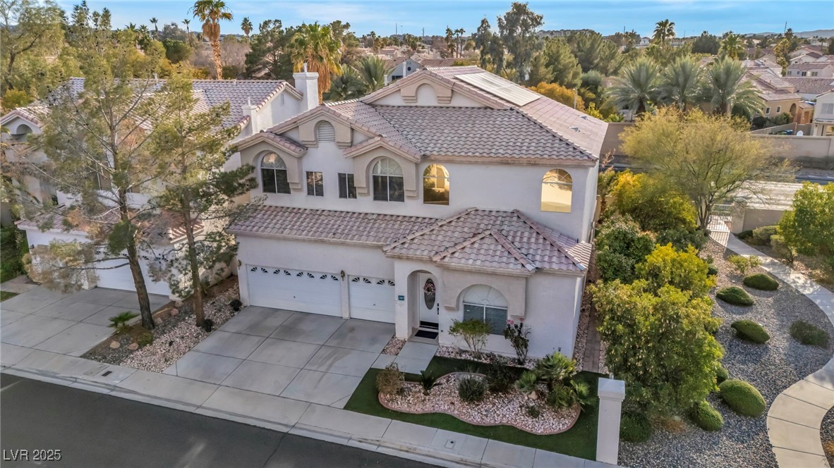 2107 Eaglepath Circle Henderson, NV 89074 - Photo 52 of 84 Mediterranean / spanish house featuring concrete driveway, a tiled roof, a chimney, stucco siding, and a garage