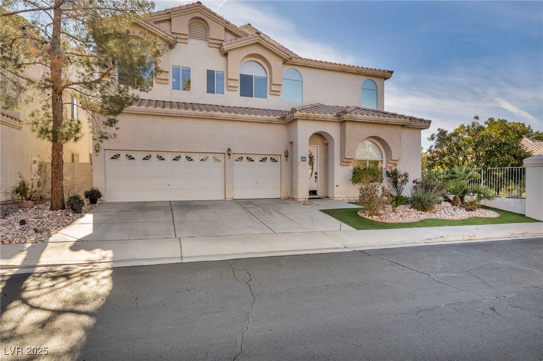 2107 Eaglepath Circle Henderson, NV 89074 - Photo 54 of 84 Mediterranean / spanish-style house with concrete driveway, stucco siding, an attached garage, and a tiled roof