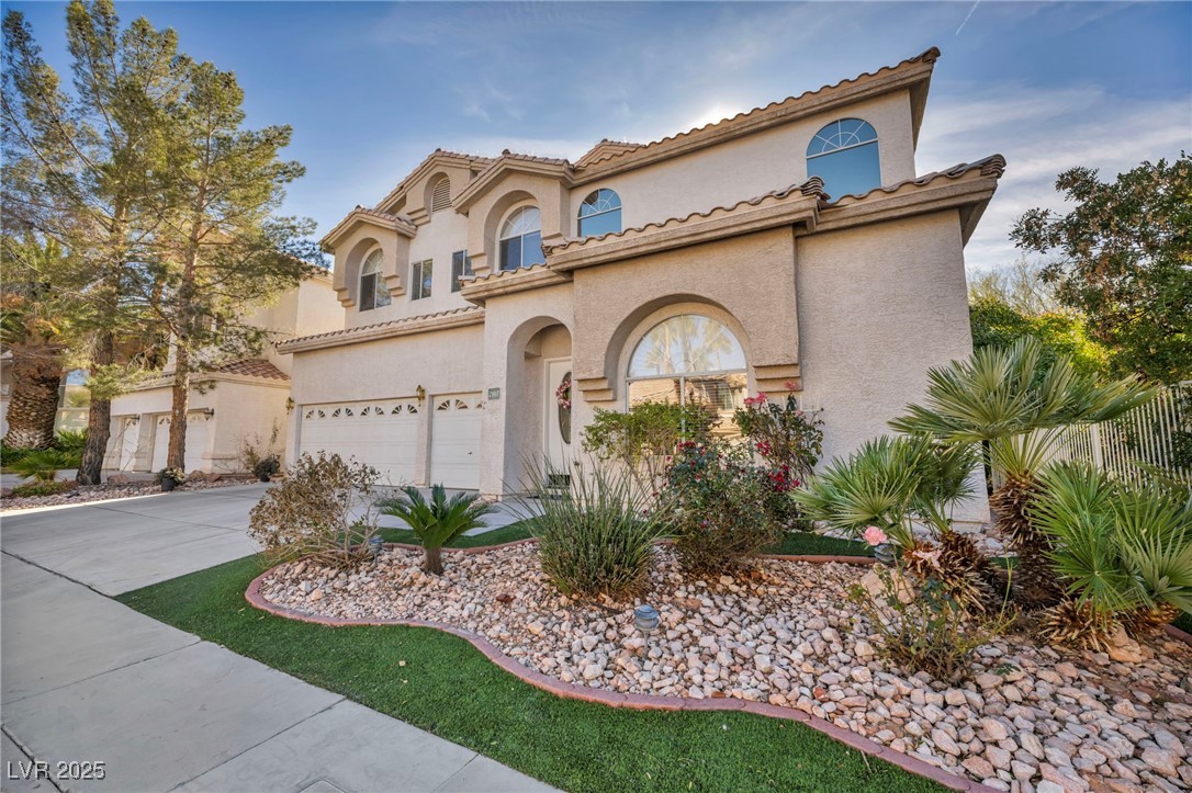 2107 Eaglepath Circle Henderson, NV 89074 - Photo 55 of 84 Mediterranean / spanish-style house featuring stucco siding, a garage, driveway, and a tiled roof