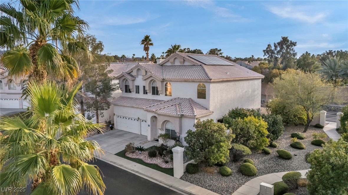 2107 Eaglepath Circle Henderson, NV 89074 - Photo 71 of 84 Mediterranean / spanish-style house with a tiled roof, stucco siding, driveway, solar panels, and an attached garage