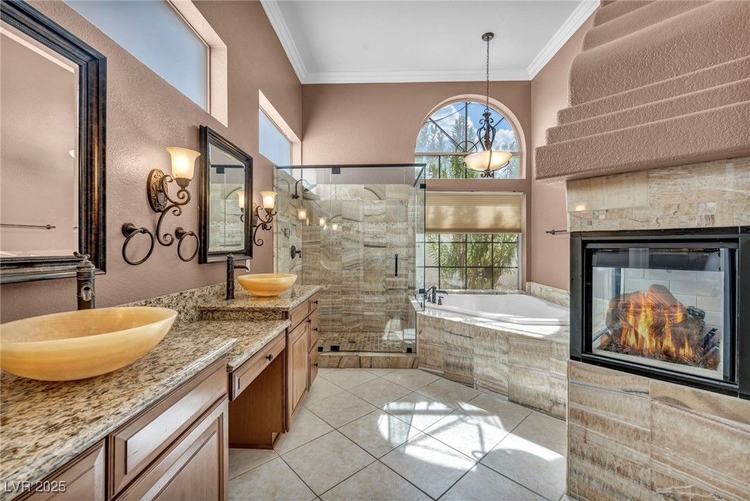 2107 Eaglepath Circle Henderson, NV 89074 - Photo 8 of 84 Full bathroom with ornamental molding, a stall shower, double vanity, a garden tub, and a multi sided fireplace
