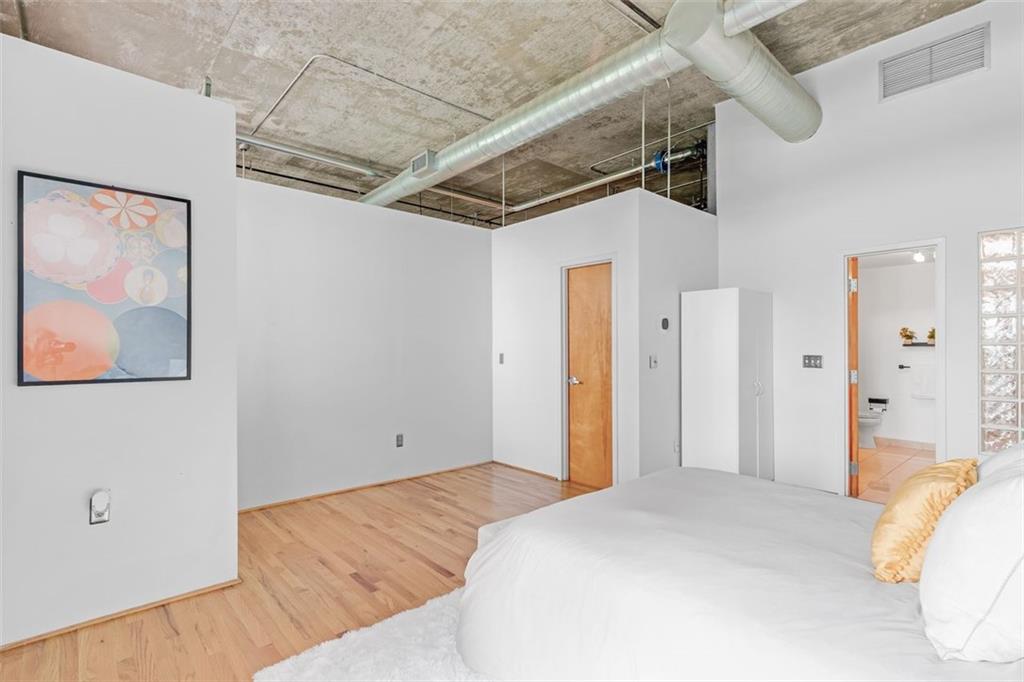 3235 Roswell Road Northeast, Unit 702 Atlanta, GA 30305 - Photo 4 of 16 a bedroom with a bed and a painting on the wall