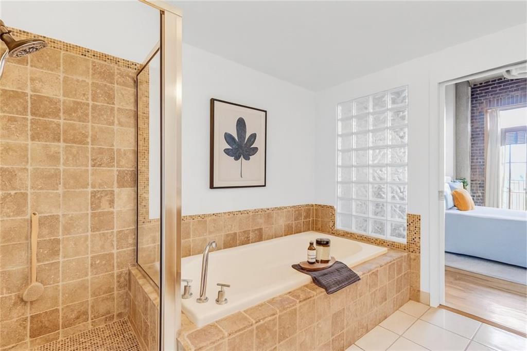 3235 Roswell Road Northeast, Unit 702 Atlanta, GA 30305 - Photo 7 of 16 a bathroom with a tub a window and a shower