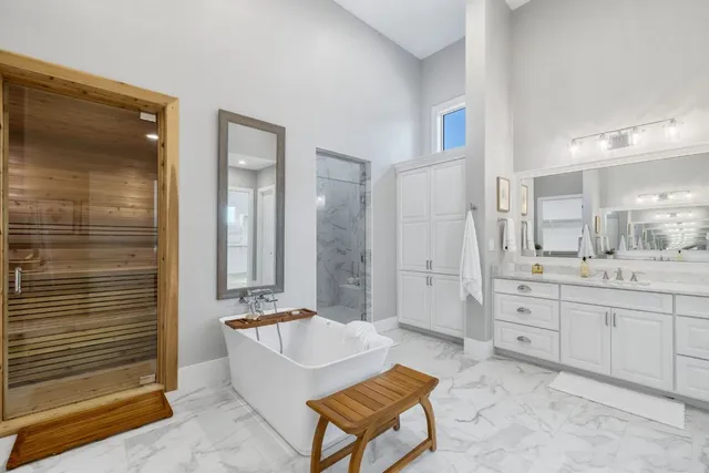 a spacious bathroom with a granite countertop sink a mirror and a shower