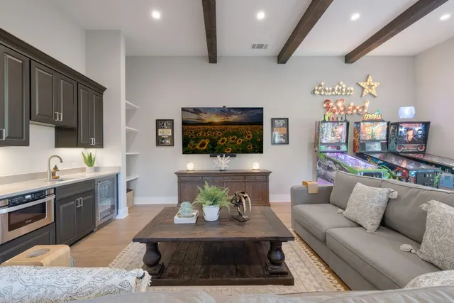 a living room with furniture a flat screen tv and kitchen view