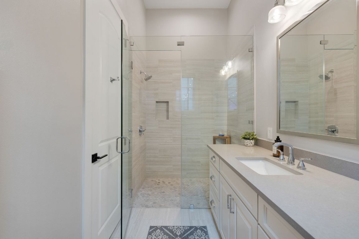 496 Primo Fiore Terrace Austin, TX 78738 - Photo 31 of 40 a bathroom with a double vanity sink mirror and shower
