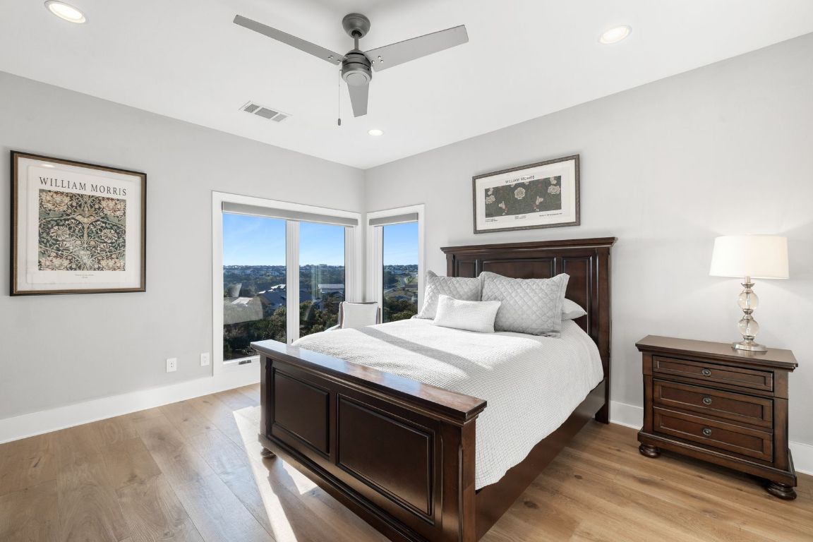 496 Primo Fiore Terrace Austin, TX 78738 - Photo 32 of 40 a large bedroom with a bed and a desk
