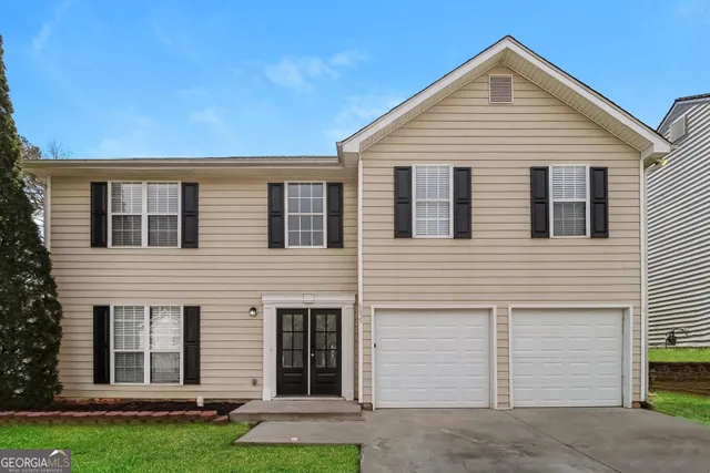 a view of a house with a yard and garage