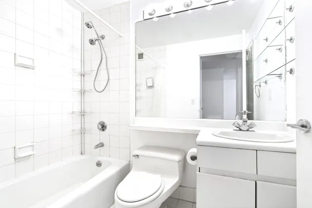 a bathroom with a sink vanity mirror and toilet