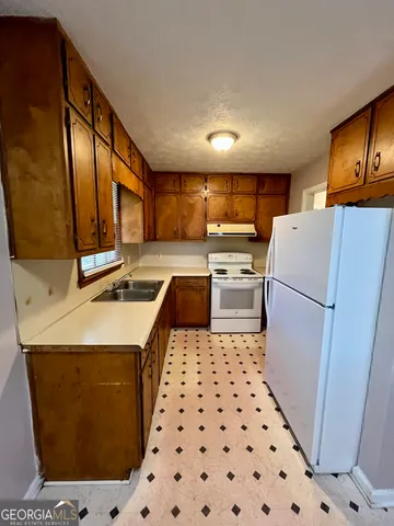 a kitchen with a refrigerator a sink and a stove