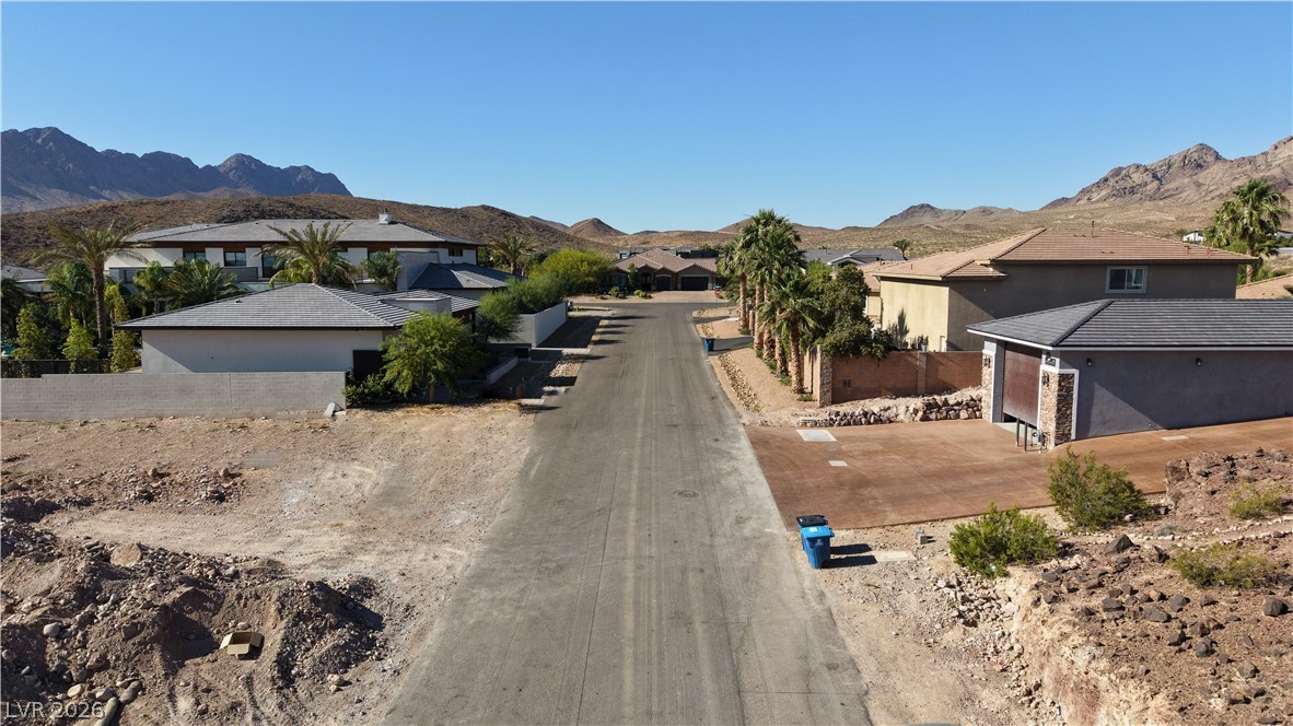 1243 Gloria Mountain Road Henderson, NV 89002 - Photo 11 of 12 An aerial perspective reveals a quiet desert neighborhood nestled against a backdrop of rugged mountains.