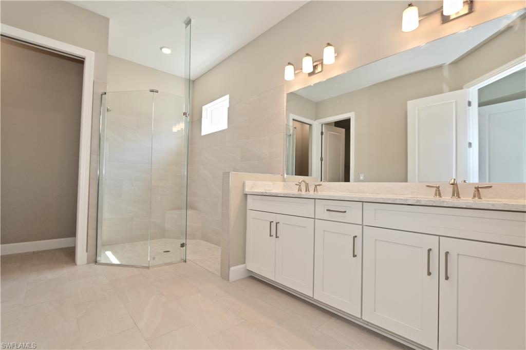 8437 Rosa Court Naples, FL 34114 - Photo 10 of 32 a bathroom with a granite countertop sink mirror and a