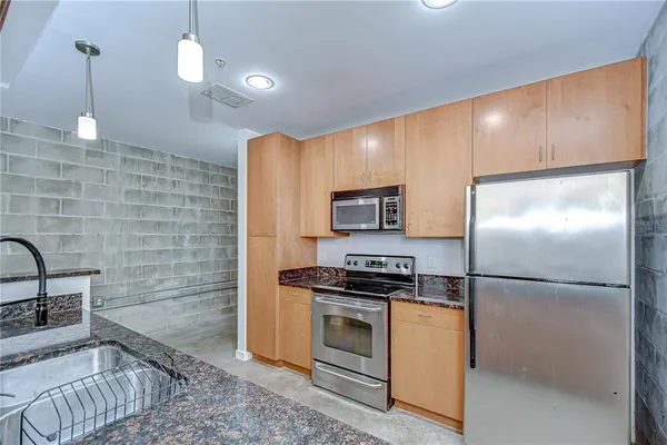 a bathroom with a granite countertop sink a mirror and shower