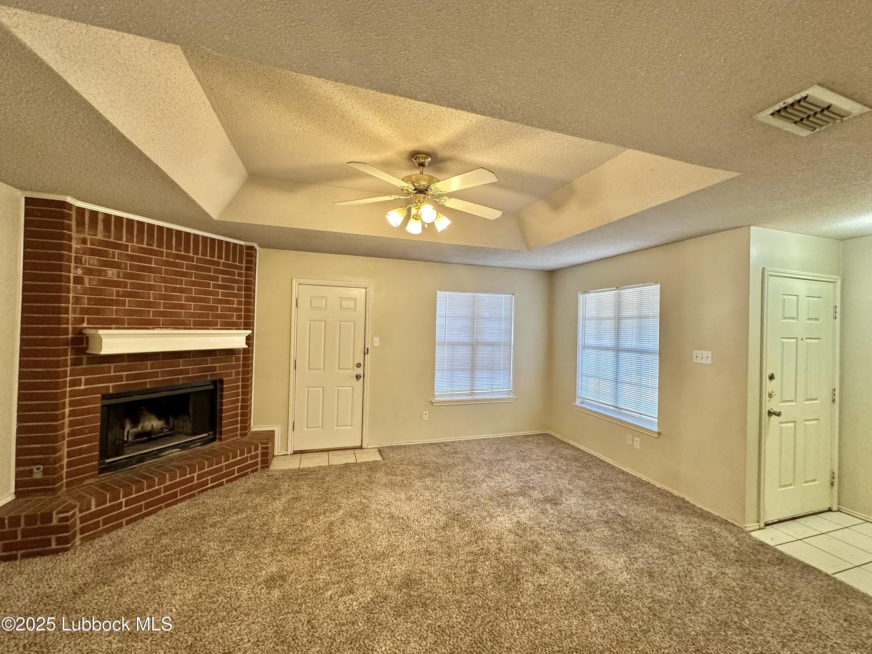 222 Grover Avenue Lubbock, TX 79416 - Photo 2 of 14 a view of an empty room with a fireplace and a window