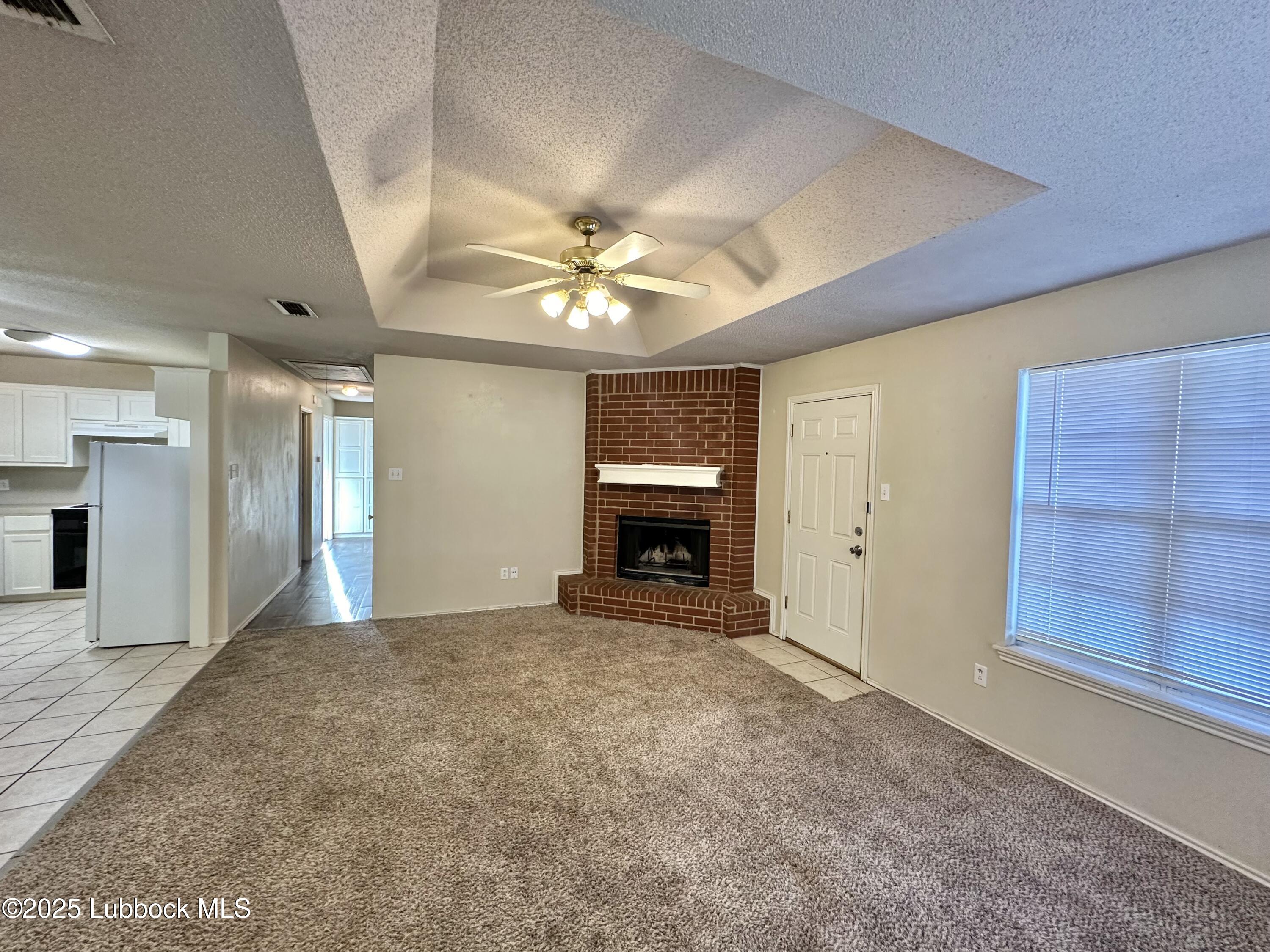 222 Grover Avenue Lubbock, TX 79416 - Photo 3 of 14 a view of an empty room with a fireplace and a window