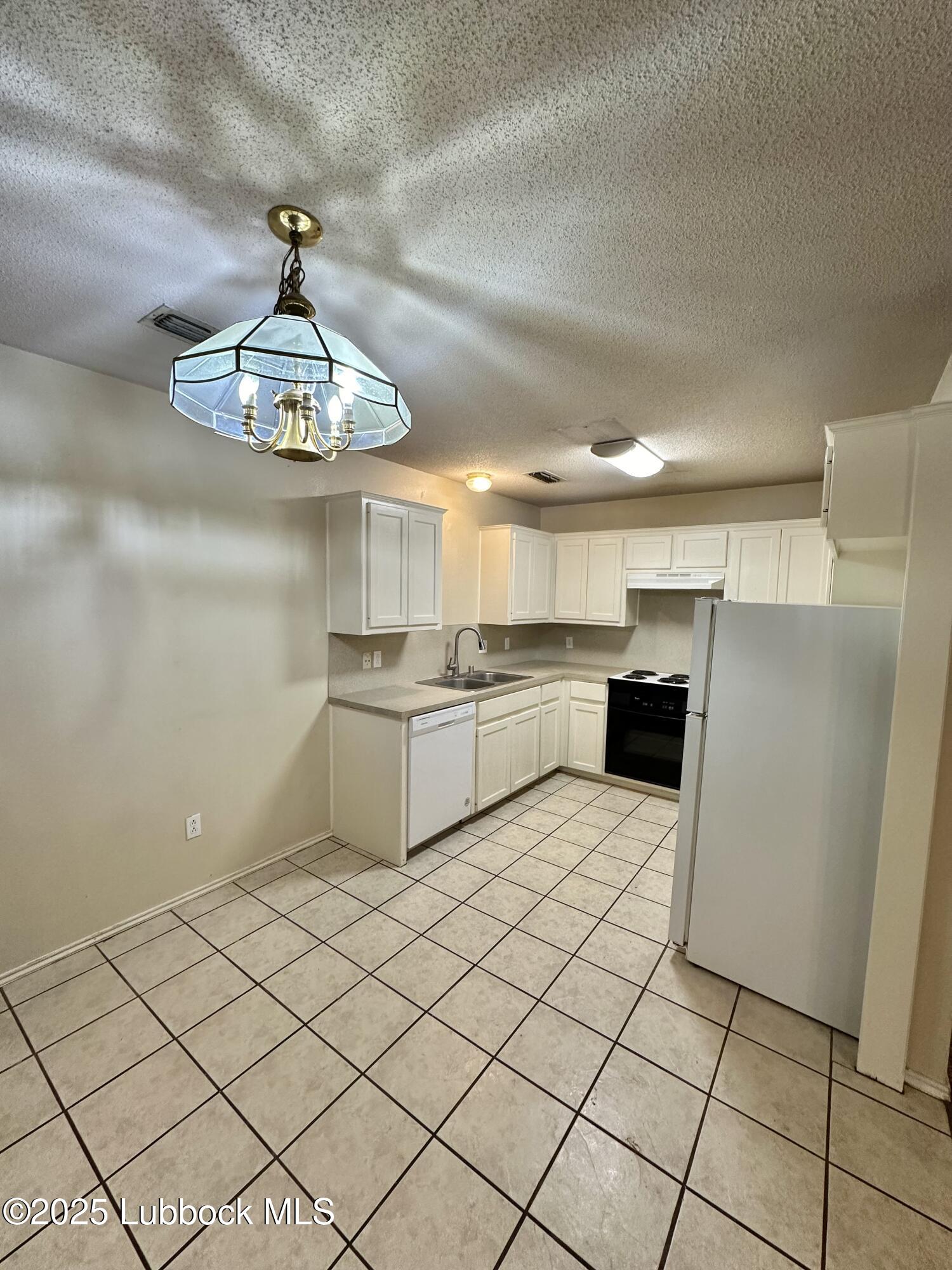 222 Grover Avenue Lubbock, TX 79416 - Photo 4 of 14 a kitchen with stainless steel appliances a sink a stove a refrigerator cabinets and furniture