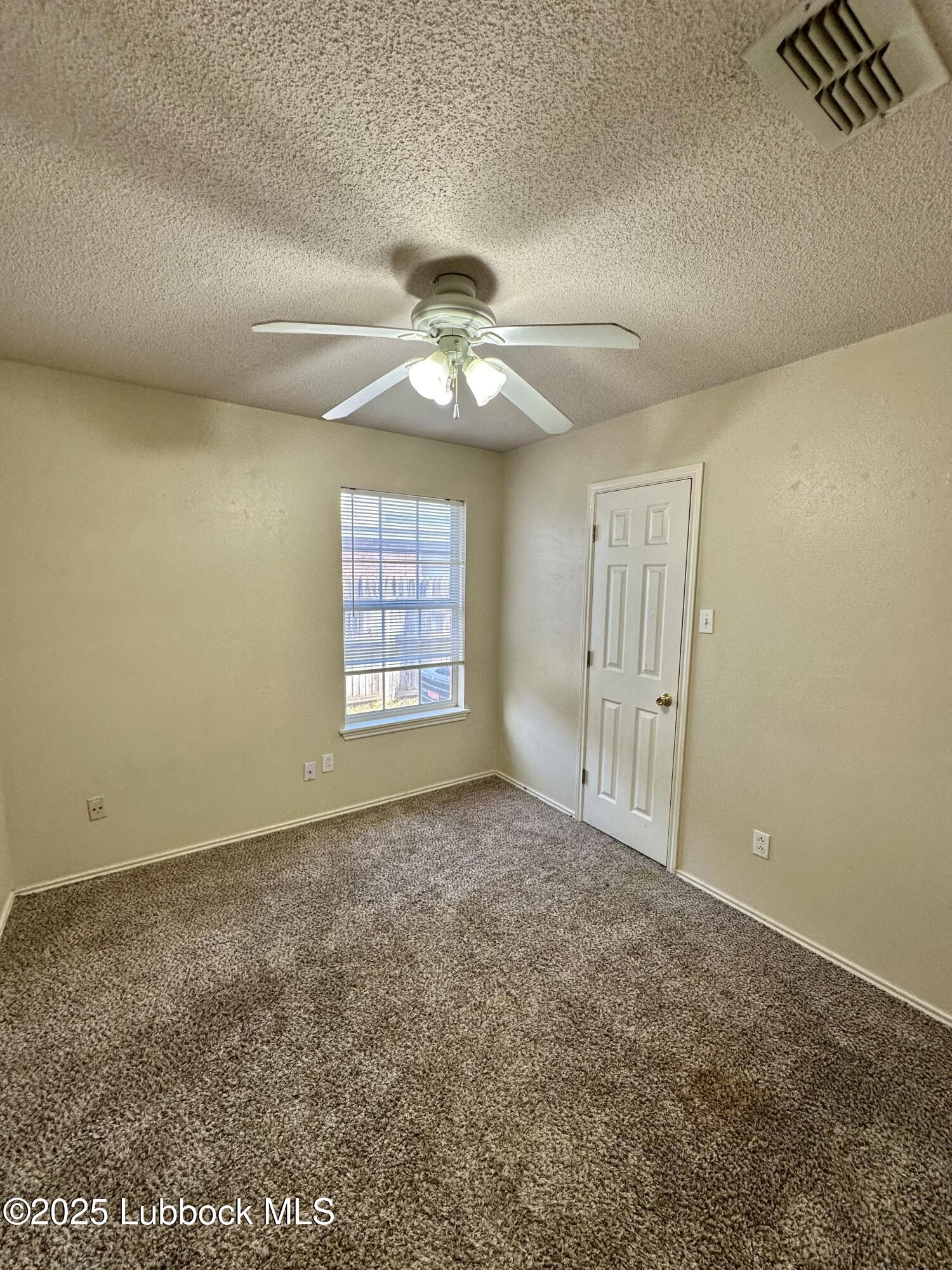 222 Grover Avenue Lubbock, TX 79416 - Photo 6 of 14 an empty room with windows and ceiling fan