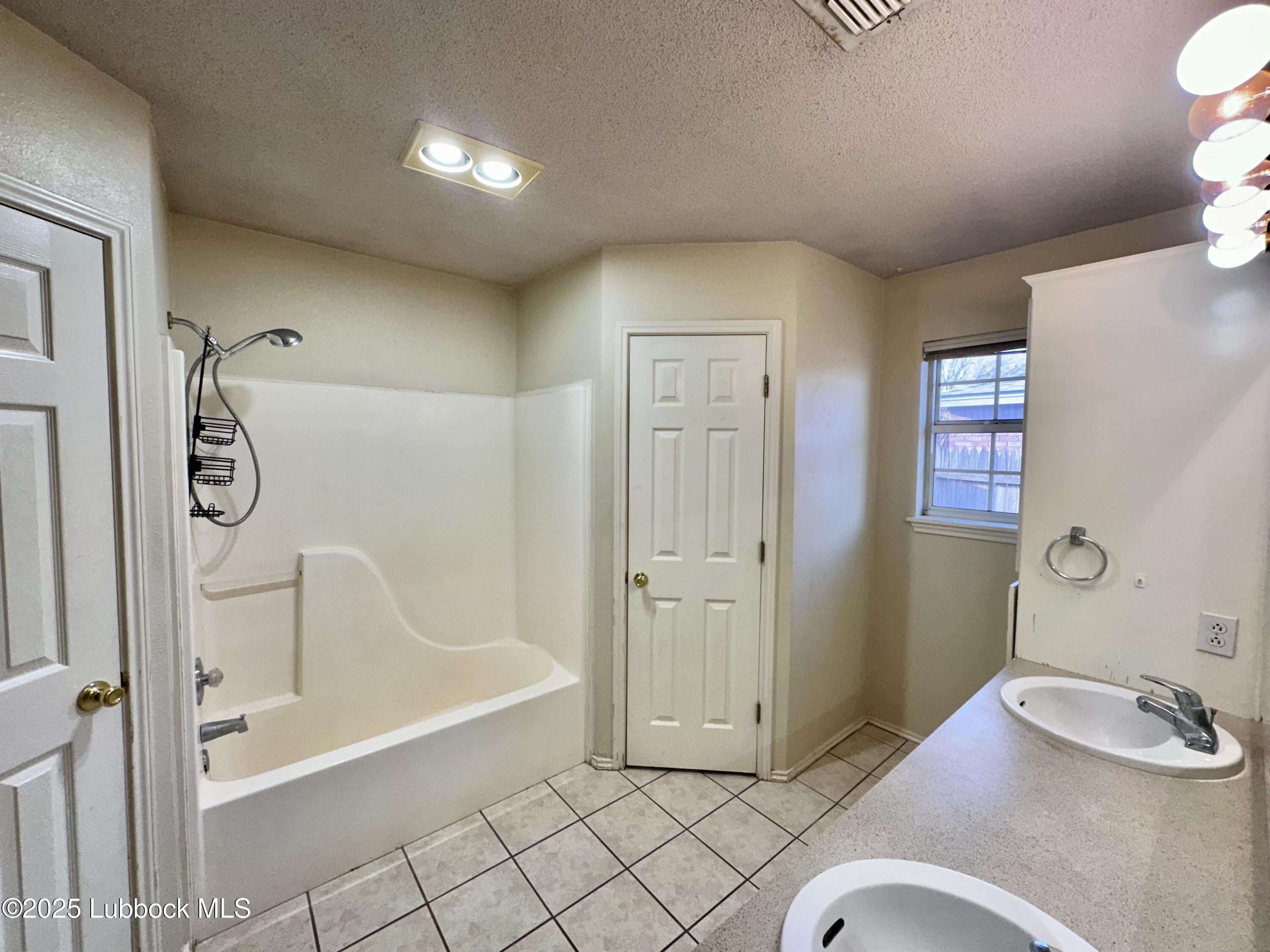 222 Grover Avenue Lubbock, TX 79416 - Photo 10 of 14 a bathroom with a tub sink and shower