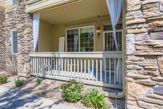 a side view of a house with a small yard and wooden floor and fence