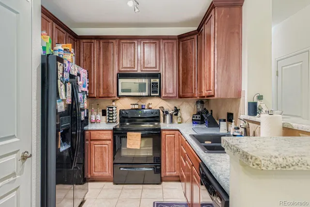 a kitchen with stainless steel appliances granite countertop a refrigerator stove and sink
