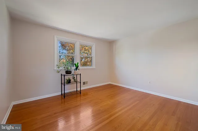 a view of an empty room with furniture and a window