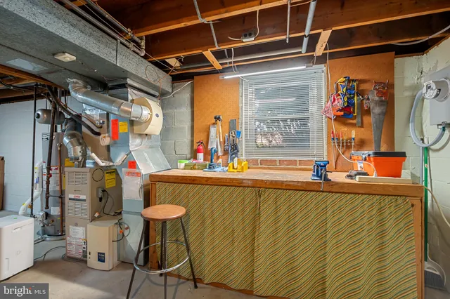 a pathway of a house with potted plants and large trees