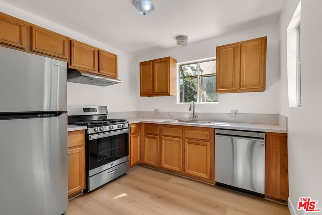 a kitchen with stainless steel appliances granite countertop a stove a sink and a refrigerator