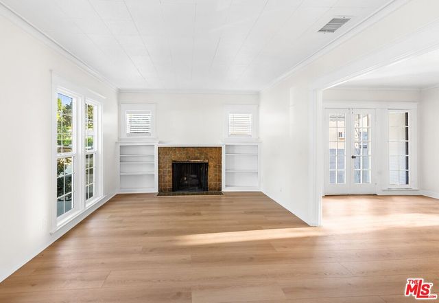 a view of an empty room with window and fire place