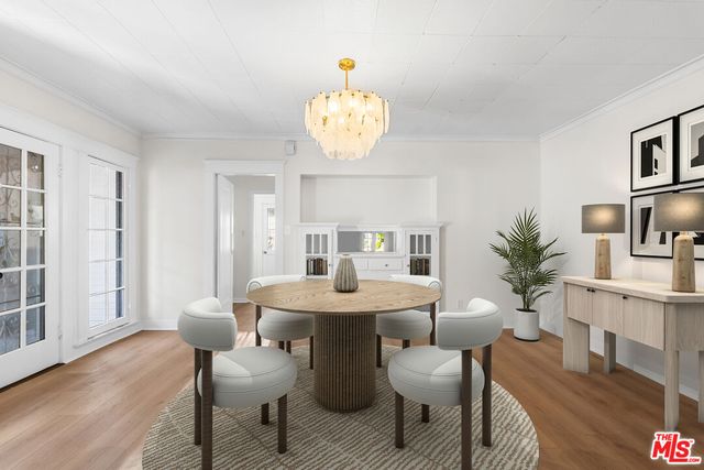 a dining room with furniture potted plants and wooden floor