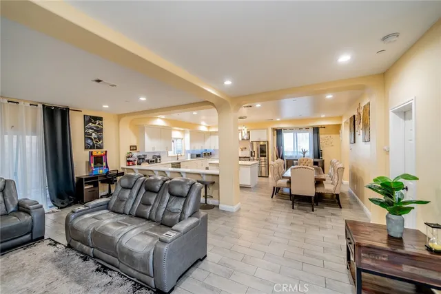 a living room with furniture kitchen view and a potted plant
