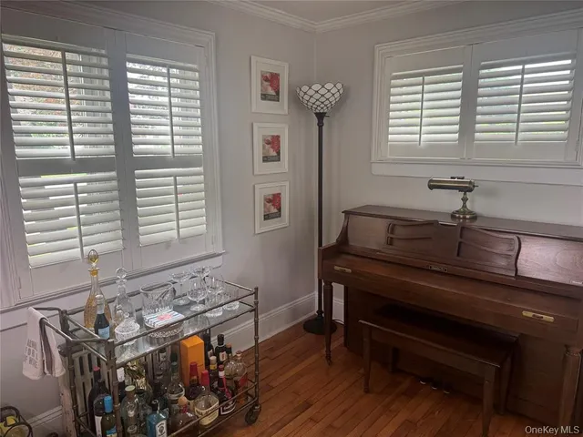a reading room with wooden floor and a window