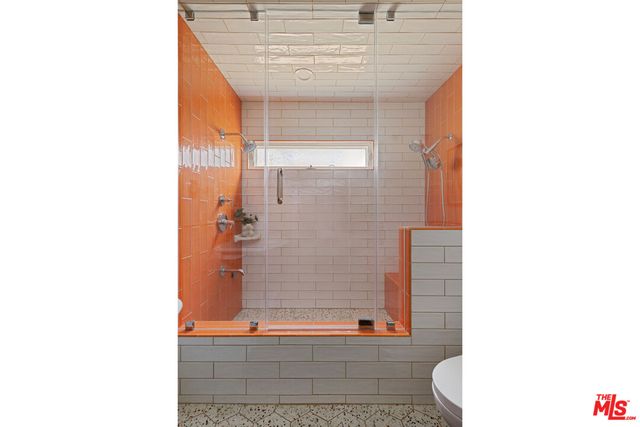 a bedroom with a bed a mirror and lamp