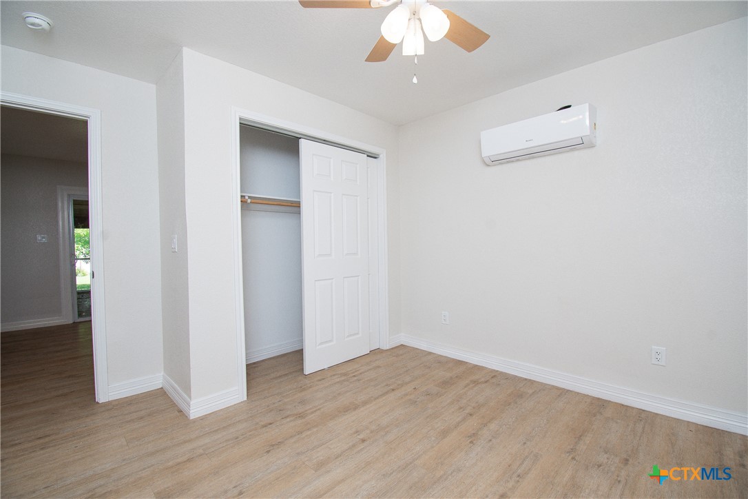 199 Apache Springs Road Briggs, TX 78608 - Photo 10 of 28 an empty room with wooden floor and chandelier fan