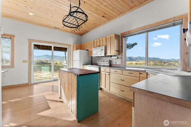 a dining hall with stainless steel appliances a dining table and chairs with wooden floor