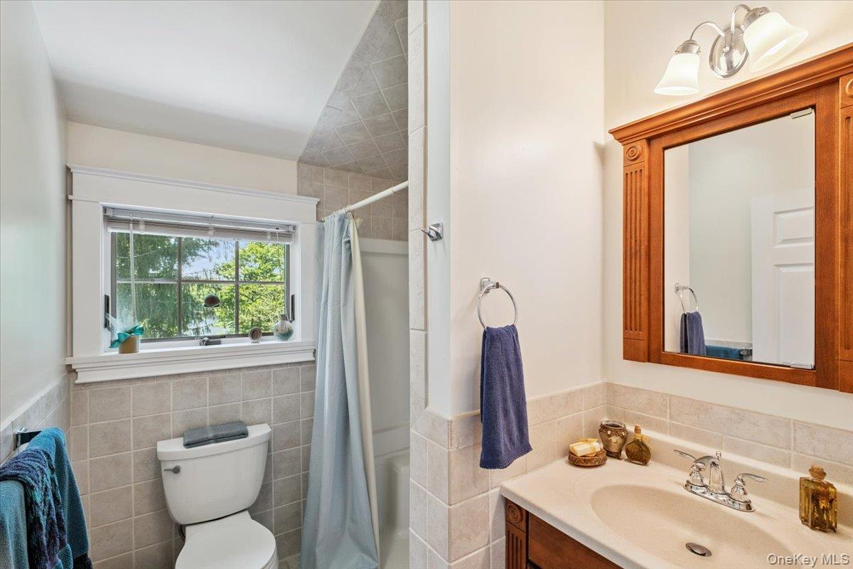 342 Lake Shore Road Putnam Valley, NY 10579 - Photo 30 of 46 Bathroom with tile walls, vanity, shower / bath combo with shower curtain, and wainscoting