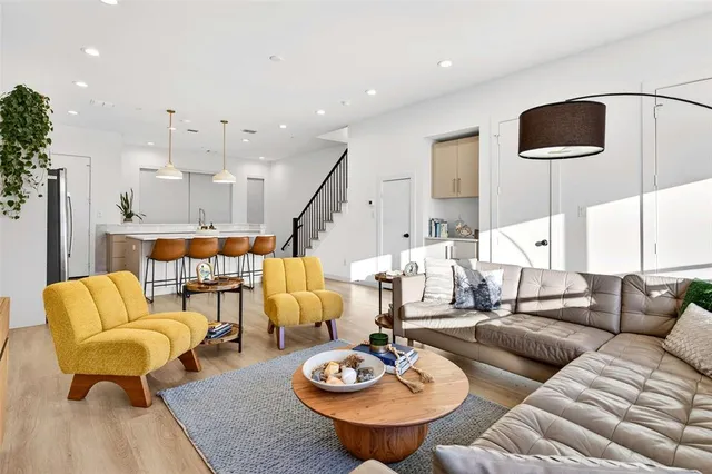 a living room with furniture and a wooden floor
