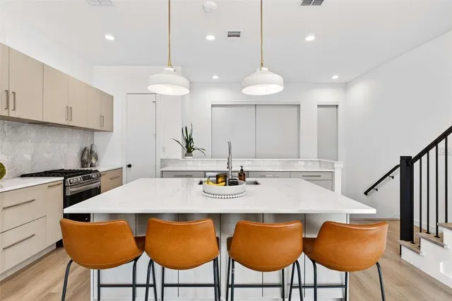 a kitchen with stainless steel appliances granite countertop a kitchen island a table and chairs in it