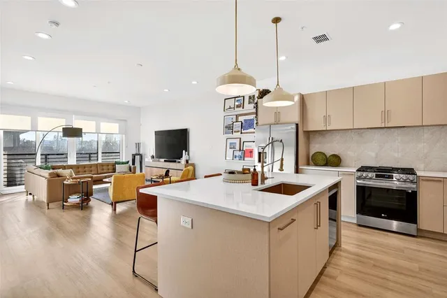 a kitchen that has a lot of cabinets in it and stainless steel appliances