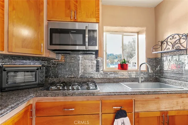 a kitchen with granite countertop a sink and a stove top oven