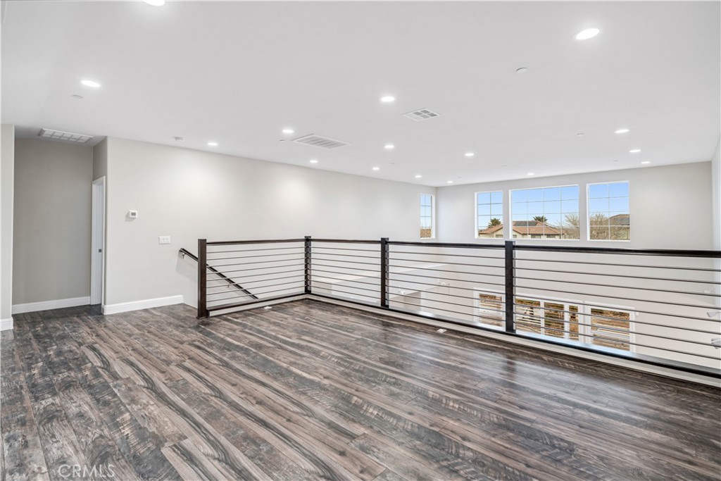 41908 Sonoma Road Palmdale, CA 93551 - Photo 43 of 75 a view of an empty room with wooden floor and a kitchen