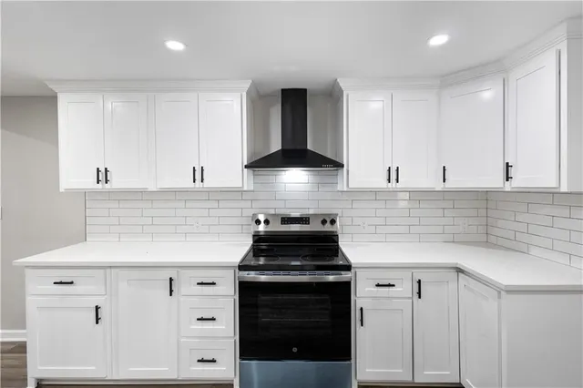 a kitchen with white cabinets and black appliances