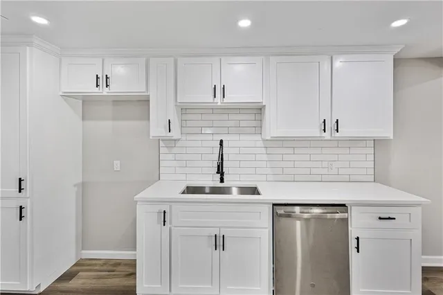 a kitchen with stainless steel appliances white cabinets and a sink
