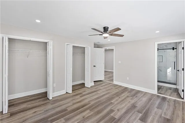 an empty room with wooden floor and a ceiling fan