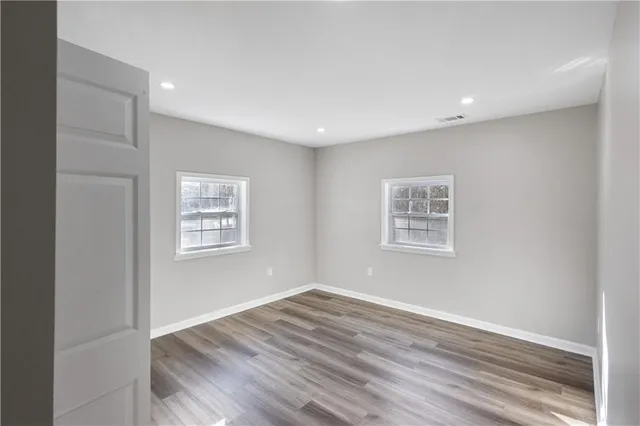 a view of empty room with wooden floor